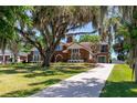 Beautiful home featuring a long driveway, mature trees draped with Spanish moss, and well-manicured lawn at 1718 Sw 27Th St, Ocala, FL 34471