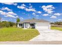 Beautiful one-story home with a two-car garage and a lush green lawn at 2329 Sw 143Rd Ct, Ocala, FL 34481