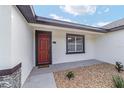 Inviting entryway showcases a red door and manicured landscaping, creating a warm welcome at 26 Water Track Dr, Ocala, FL 34472