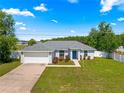 Inviting home exterior featuring lush lawn, attached garage, and a welcoming front entrance at 27 Juniper Dr, Ocala, FL 34480