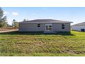 The backyard features a well-kept lawn, and a patio, offering a serene outdoor space and natural light at 2900 Sw 159 Ct, Ocala, FL 34481