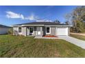 Charming single-story home with a well-maintained lawn, grey exterior and attached garage, perfect for modern living at 2900 Sw 159 Ct, Ocala, FL 34481