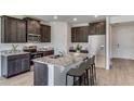 Modern kitchen features stainless steel appliances, dark cabinetry, and a granite countertop island with bar stool seating at 4188 Sw 53Rd Lane Rd, Ocala, FL 34474