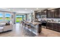 Open-concept kitchen with a large island, stainless steel appliances, dark cabinetry, and seamless flow to the living area at 4196 Sw 53Rd Lane Rd, Ocala, FL 34474