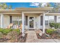 Inviting front porch with seating area, decorative plants, and a welcoming entrance at 6127 Sw 84Th Place Rd, Ocala, FL 34476