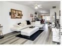 Modern living room with white furniture, stylish decor, ceiling fan, and ample natural light at 6127 Sw 84Th Place Rd, Ocala, FL 34476