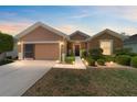 Charming single-story home with garage and landscaped front yard, illuminated by path lighting at dusk at 7432 Sw 98Th Ave, Ocala, FL 34481