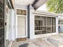 Covered patio with tiled flooring, screened walls, and a door leading to the outside at 8051 Sw 115 Loop, Ocala, FL 34481