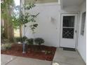Welcoming front door with decorative security bars surrounded by beautiful greenery and mulch at 8132 Fairways Cir # R103, Ocala, FL 34472