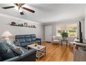 Open-concept living room showcases hardwood floors, a ceiling fan, and comfortable seating, perfect for relaxation at 8625 Sw 94Th Ln # D, Ocala, FL 34481