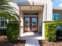 Elegant front door featuring decorative glass, sidelights, and a covered entrance at 9347 Se 137Th Street Rd, Summerfield, FL 34491