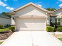 Attached two car garage with bright lighting and clean, well-maintained driveway at 9347 Se 137Th Street Rd, Summerfield, FL 34491
