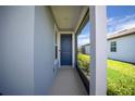 Inviting entryway showcasing a vibrant blue door with modern hardware and an attached screen room at 9388 Sw 53Rd Pl, Ocala, FL 34481