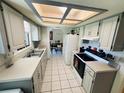 Bright kitchen with tile floor, white cabinets, and skylight for natural lighting at 10081 Sw 93Rd Ave, Ocala, FL 34481