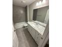 Bathroom featuring tiled walls, a shower and tub, and a vanity with storage underneath at 10785 Sw 130Th Ct, Dunnellon, FL 34432