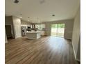 Open concept living room with wood flooring and a kitchen island, perfect for entertaining at 10785 Sw 130Th Ct, Dunnellon, FL 34432