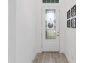 Clean and bright entryway with wood-look tile flooring, white walls, and decorative wall art at 1119 Se 42Nd Rd, Ocala, FL 34480