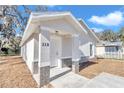 The house boasts a clean white exterior and inviting front entrance for a welcoming feel at 11415 Nw 15Th St, Ocala, FL 34482