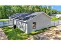 An exterior of the back of the house featuring a metal fence and grass at 11415 Nw 15Th St, Ocala, FL 34482