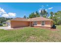 Lovely single-story home features a green lawn with mulch landscaping and beautiful blue sky at 13173 Sw 65Th Cir, Ocala, FL 34473