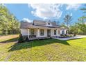 Beautiful single-story home with a covered porch, modern accents, and a well-manicured lawn at 14115 Nw 141St Ave, Williston, FL 32696