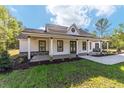 Inviting single-story home showcasing a charming covered porch and well-maintained landscaping at 14115 Nw 141St Ave, Williston, FL 32696