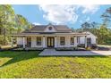 Charming one-story home with a covered porch and lush green lawn, creating a welcoming curb appeal at 14115 Nw 141St Ave, Williston, FL 32696
