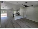 Open-concept living space with sleek gray floors, modern lighting, and seamless flow to the kitchen at 22764 Sw Sea Cliff Ave, Dunnellon, FL 34431