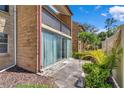 Exterior view of condo featuring sliding glass doors and a private balcony nestled among lush landscaping at 2837 Ne 3Rd St # 103, Ocala, FL 34470
