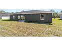 This home features a spacious backyard with sliding glass doors and a small concrete patio at 4073 Se 136Th Pl, Summerfield, FL 34491