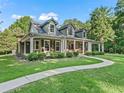 Beautiful home featuring a long porch, lush landscaping, and an inviting walkway at 6577 Nw 193Rd St, Micanopy, FL 32667