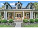 Charming front porch with rocking chairs, hanging plants, and a welcoming entryway at 6577 Nw 193Rd St, Micanopy, FL 32667