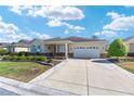 Attractive home boasts a pristine lawn, stone accents, and a driveway leading to the garage at 9728 Sw 95Th Loop, Ocala, FL 34481