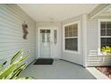 Inviting front entrance with a decorative door, sidelights, and a covered porch with a window at 16751 Se 84Th Colerain Cir, The Villages, FL 32162
