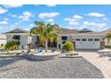Inviting home boasting a landscaped front yard with palm trees, a brick driveway, and a two-car garage at 10293 Sw 96Th Ln, Ocala, FL 34481