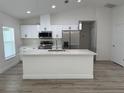 Modern kitchen featuring stainless steel appliances, white cabinetry, and an island with seating at 11165 Nw 7Th St, Ocala, FL 34482