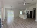 Bright, open-concept living area featuring light floors, a kitchen island, and stainless steel appliances at 11165 Nw 7Th St, Ocala, FL 34482