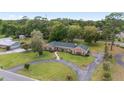 Expansive aerial view of a brick home with a circular driveway and lush green lawn at 1866 Ne 39Th Ct, Ocala, FL 34470