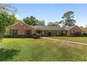 Charming brick home features green shutters, a well-manicured lawn, and inviting curb appeal at 1866 Ne 39Th Ct, Ocala, FL 34470