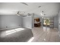 Open concept living area with carpet, tile flooring, ceiling fan, and sliding glass doors to the patio at 2199 Se 175Th Ter, Silver Springs, FL 34488