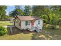 Charming home featuring a bright red front door, cozy porch, and well-maintained lawn at 2300 Ne 49Th St, Ocala, FL 34479
