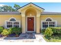 Inviting front entrance with arched windows and a beautifully landscaped garden at 3011 Se 46Th Ave, Ocala, FL 34480