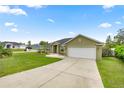 View of the home's well-maintained exterior with a spacious driveway and green lawn at 4324 Sw 98Th Ln, Ocala, FL 34476