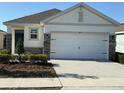 Charming single-story home with neutral siding, stone accents, and a spacious two-car garage at 5077 Stokes Way, Wildwood, FL 34785