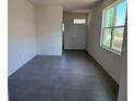A spacious living room with ceramic tile flooring and a large window providing natural light at 5077 Stokes Way, Wildwood, FL 34785