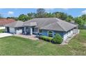 Aerial view of light blue one-story home, with a well-manicured green lawn and mature landscaping at 5350 Sw 82Nd St, Ocala, FL 34476