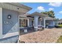 Covered front porch with stone walkway and seating area and light blue siding at 5350 Sw 82Nd St, Ocala, FL 34476