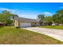 Ranch-style home showcasing its attached garage, neutral siding, and well-kept front yard at 5580 Se 21St Ln, Ocala, FL 34480