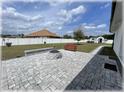 Backyard oasis features a brick paver patio with a fire pit, bench, and white vinyl fencing at 6365 Se 12Th Ln, Ocala, FL 34472