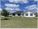 Inviting single-story home with a well-manicured lawn and sleek black window trim at 6365 Se 12Th Ln, Ocala, FL 34472